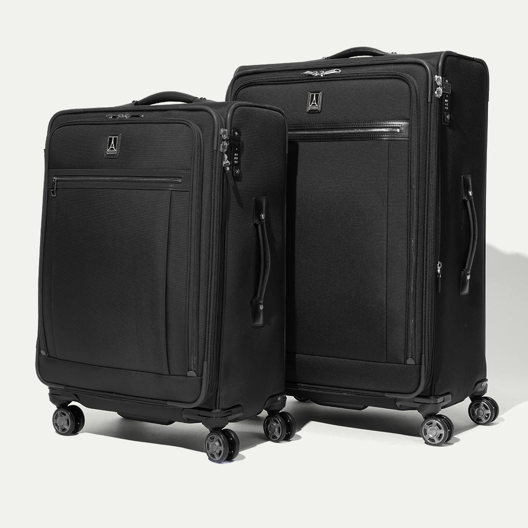 Two black softside suitcases on a white background