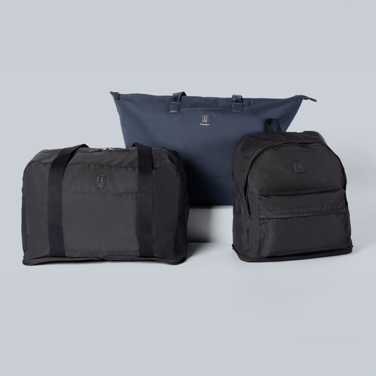 Three black bags of different sizes on a light gray background