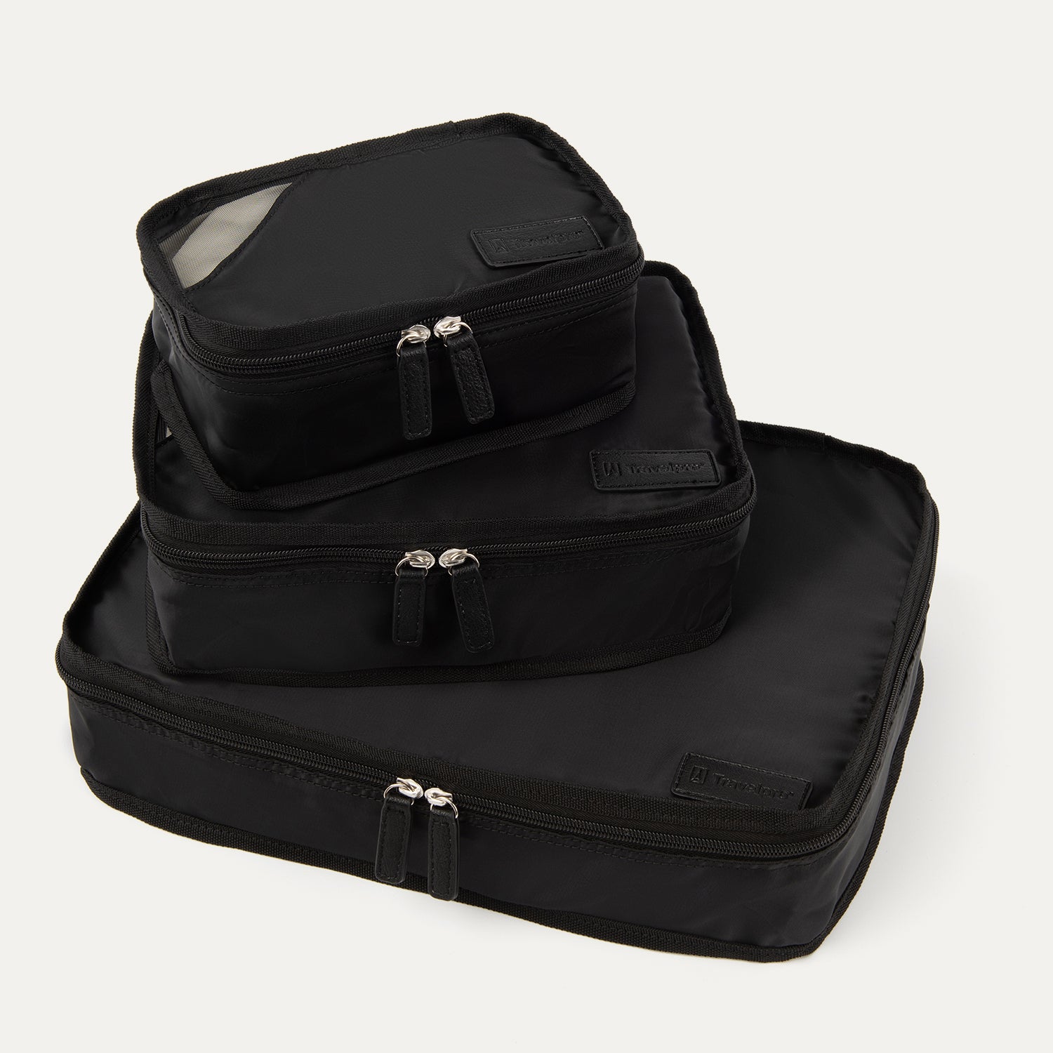 A set of three black Travelpro packing cubes, with the largest at the bottom, medium in the middle, and the smallest at the top, all with zipper closures.