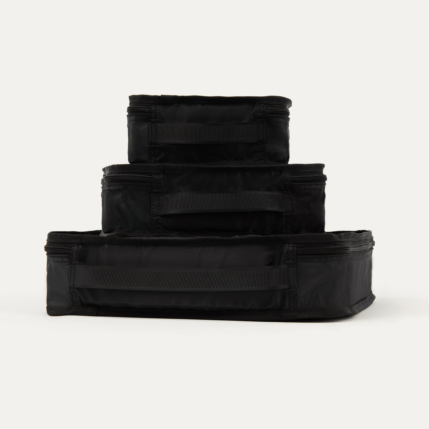 Rear view of Travelpro Essentials 3 Pack Packing Cube Set (S/M/L) in BLACK, stacked to show integrated grab handles.