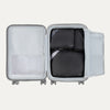 Top view of Travelpro Essentials 3 Pack Packing Cube Set in BLACK, efficiently arranged inside an open hardside carry-on.