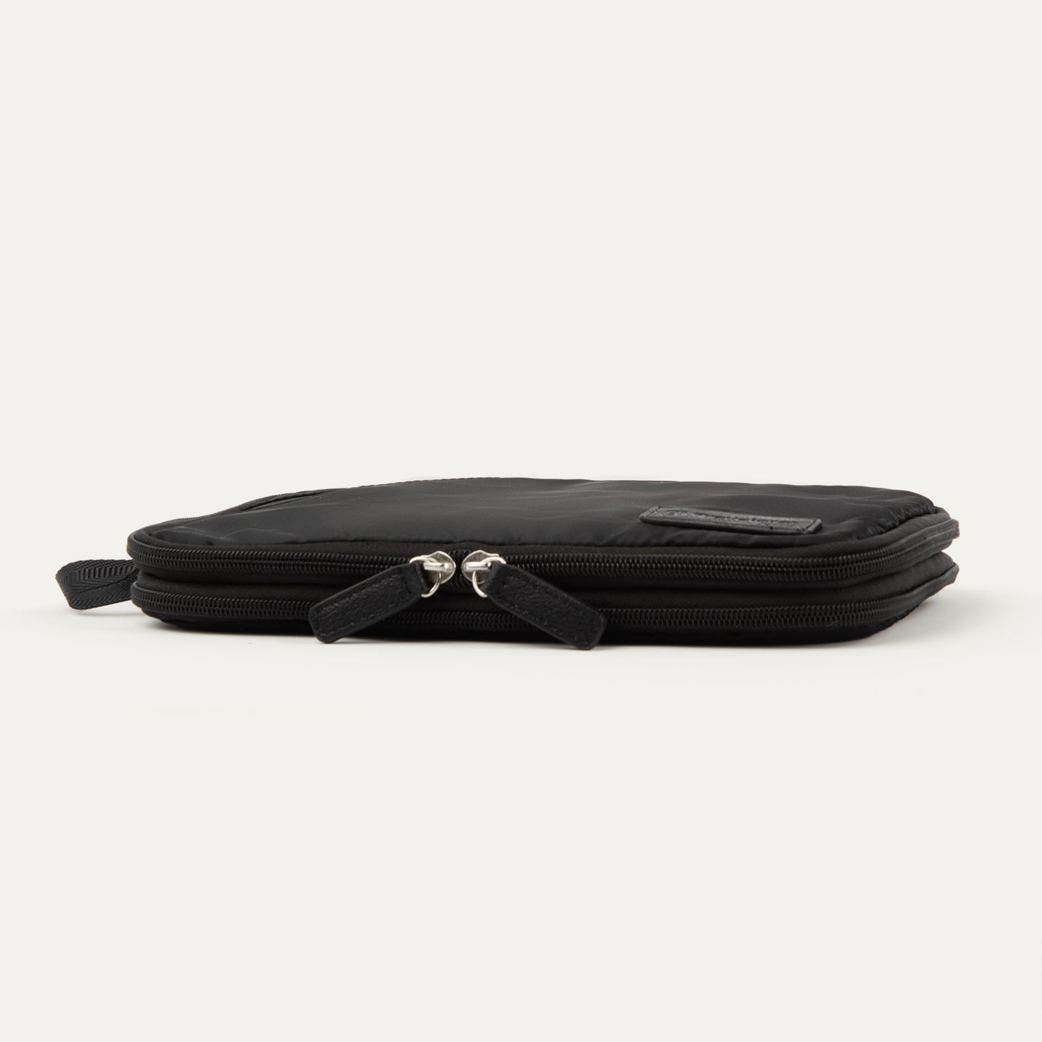 Compressed view of the Travelpro® Medium Packing Cube in black with dual zippers and a side handle.