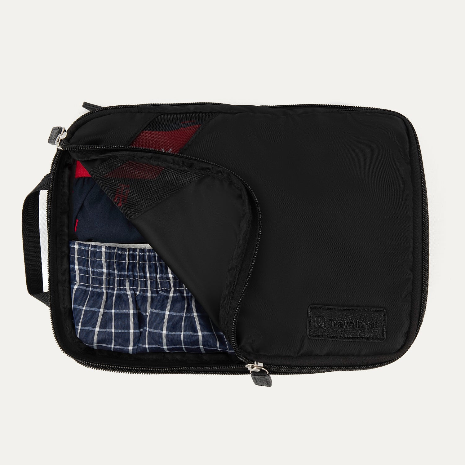 Travelpro® Medium Packing Cube in black, shown partially unzipped with clothes neatly packed inside.