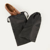 A pair of black Travelpro Essentials shoe bags with a single shoe placed in one of the bags, on a white background.
