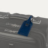 Travelpro Essentials Leather Luggage Tag in Navy, attached to suitcase handle with secure buckle strap.