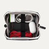 Top view of the Travelpro MaxAccess Cubes™ Large Organizer in black with a white zipper, neatly packed with electronics and secured with interior elastic straps.