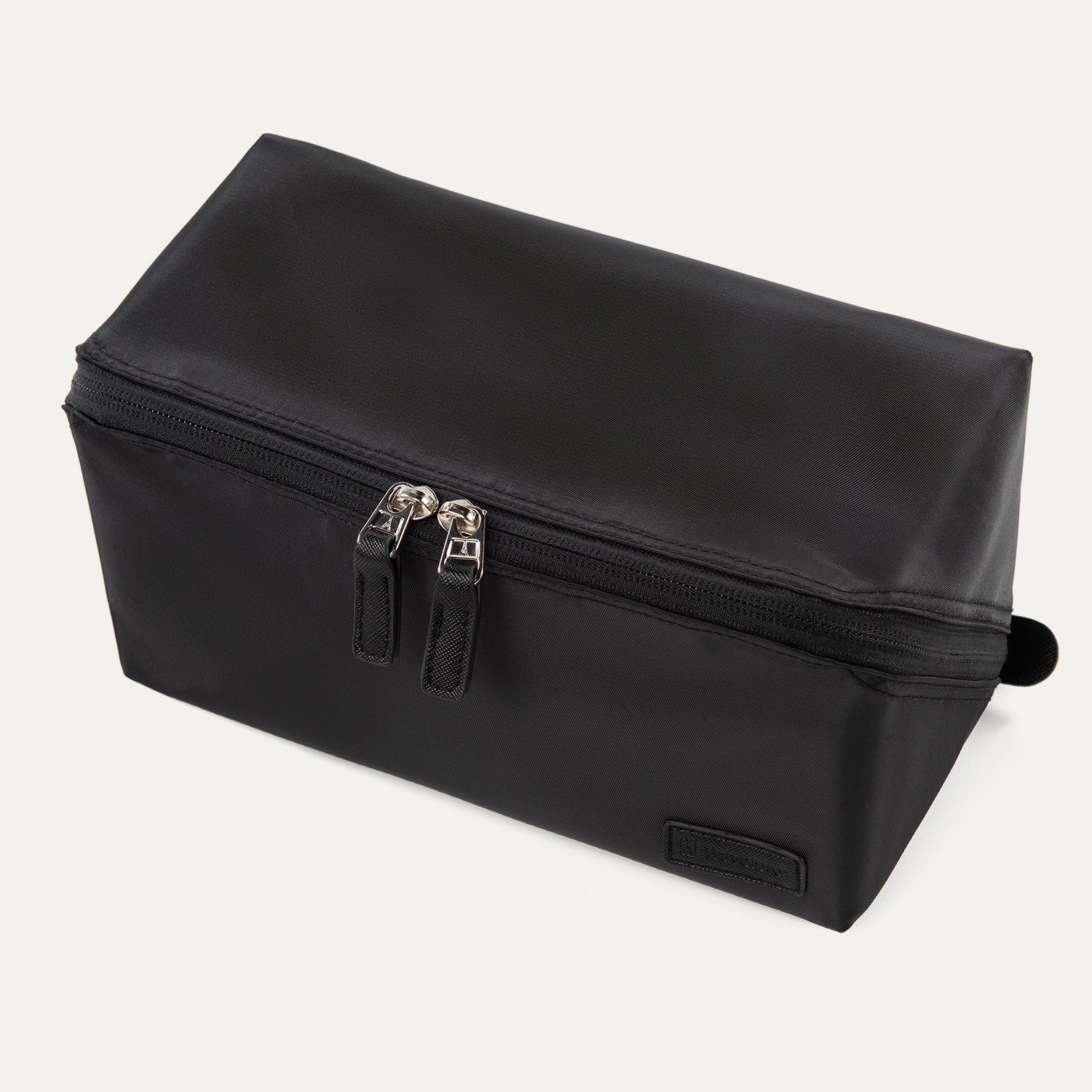 Front angled view of the Travelpro® MaxAccess Cubes™ Toiletry Organizer in black with dual zippers and a structured rectangular design.