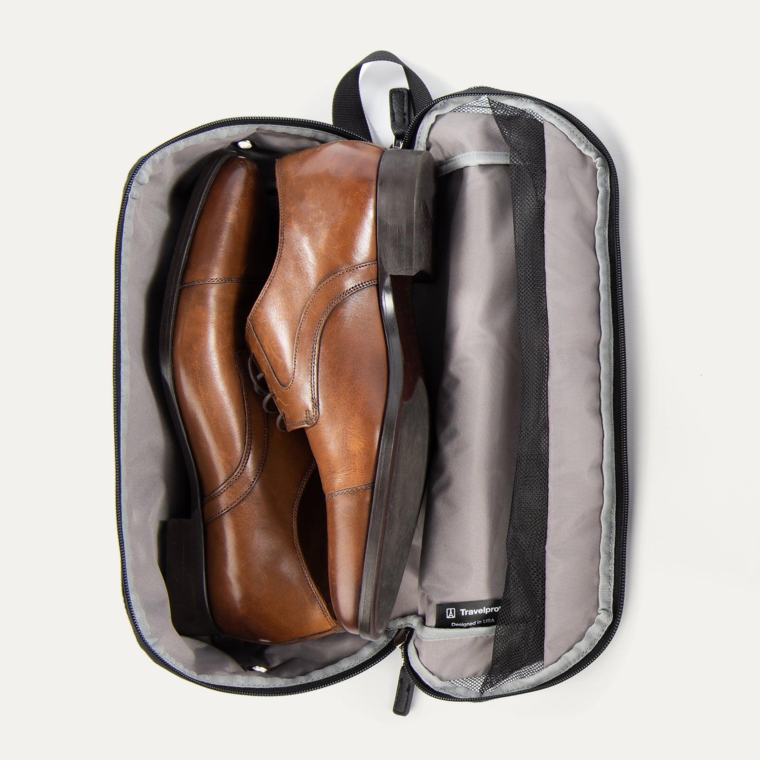 Travelpro MaxAccess Cubes™ Large Shoe Organizer in black, unzipped and open, holding a pair of brown leather dress shoes