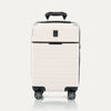 Front view of T+L Carry-On Spinner in White Sand, showing a hard shell with black trim, horizontal grooves, and dual spinner wheels.