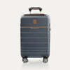 Front view of T+L Carry-On Spinner in Monaco Blue, featuring a matte hard shell, brown contrast trim, horizontal grooves, and dual spinner wheels.