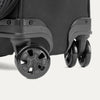 Close up look on black suitcase with black wheels on a white background