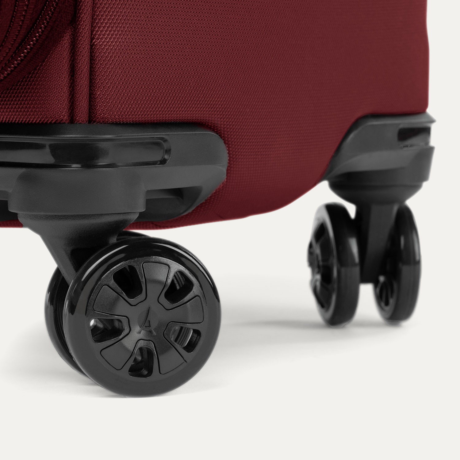 Close-up of the 360° spinner wheels on the Crew™ Classic Spinner in Rosewood Red.
