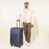 Man standing with Travelpro® Crew™ Classic Large Check-In Spinner in Patriot Blue.