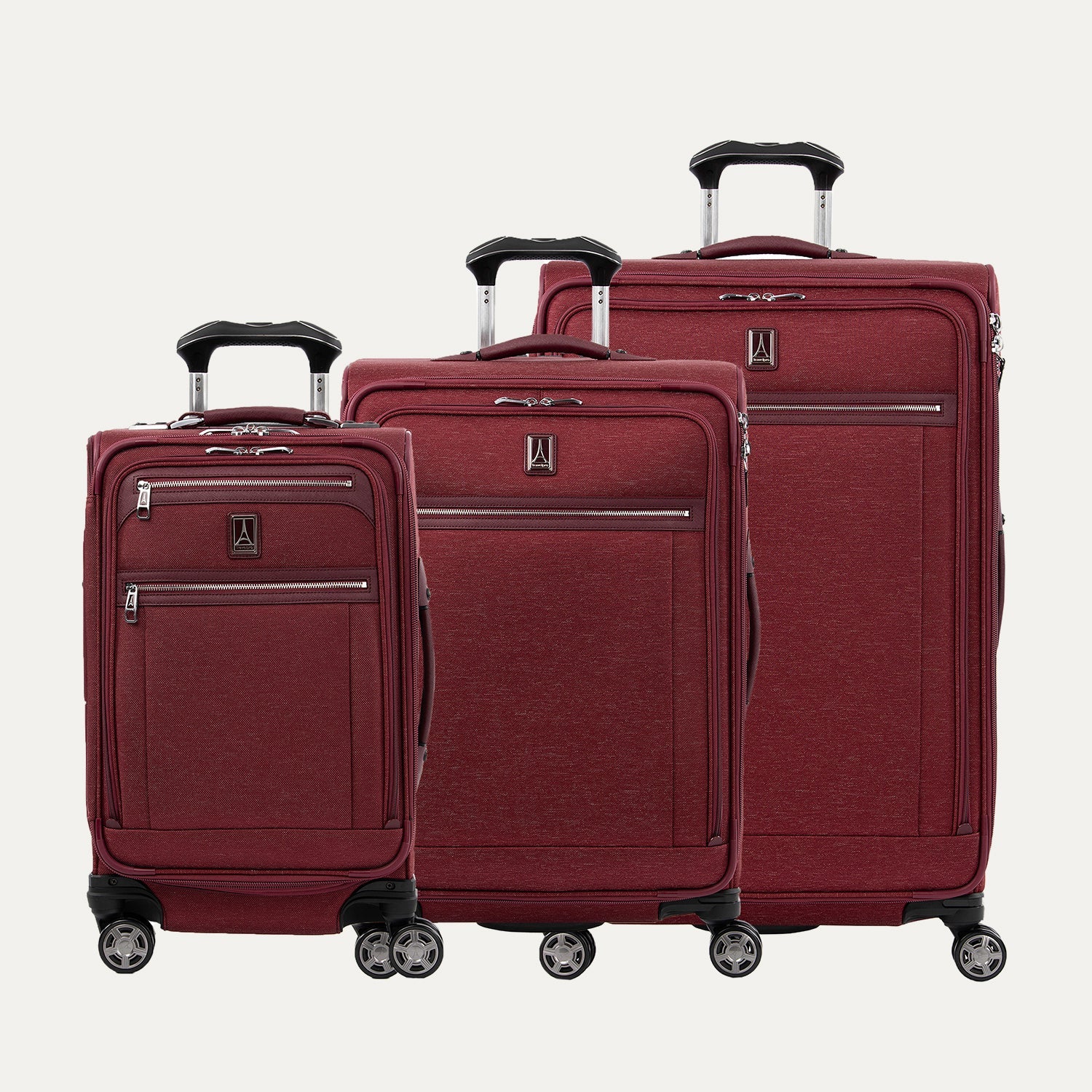 A set of three expandable spinner luggage bags in red color, including a carry-on size and two larger sizes, with chrome zippers and a leather accent on the front pocket.