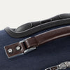 Close-up of a blue suitcase handle with a brown leather strap