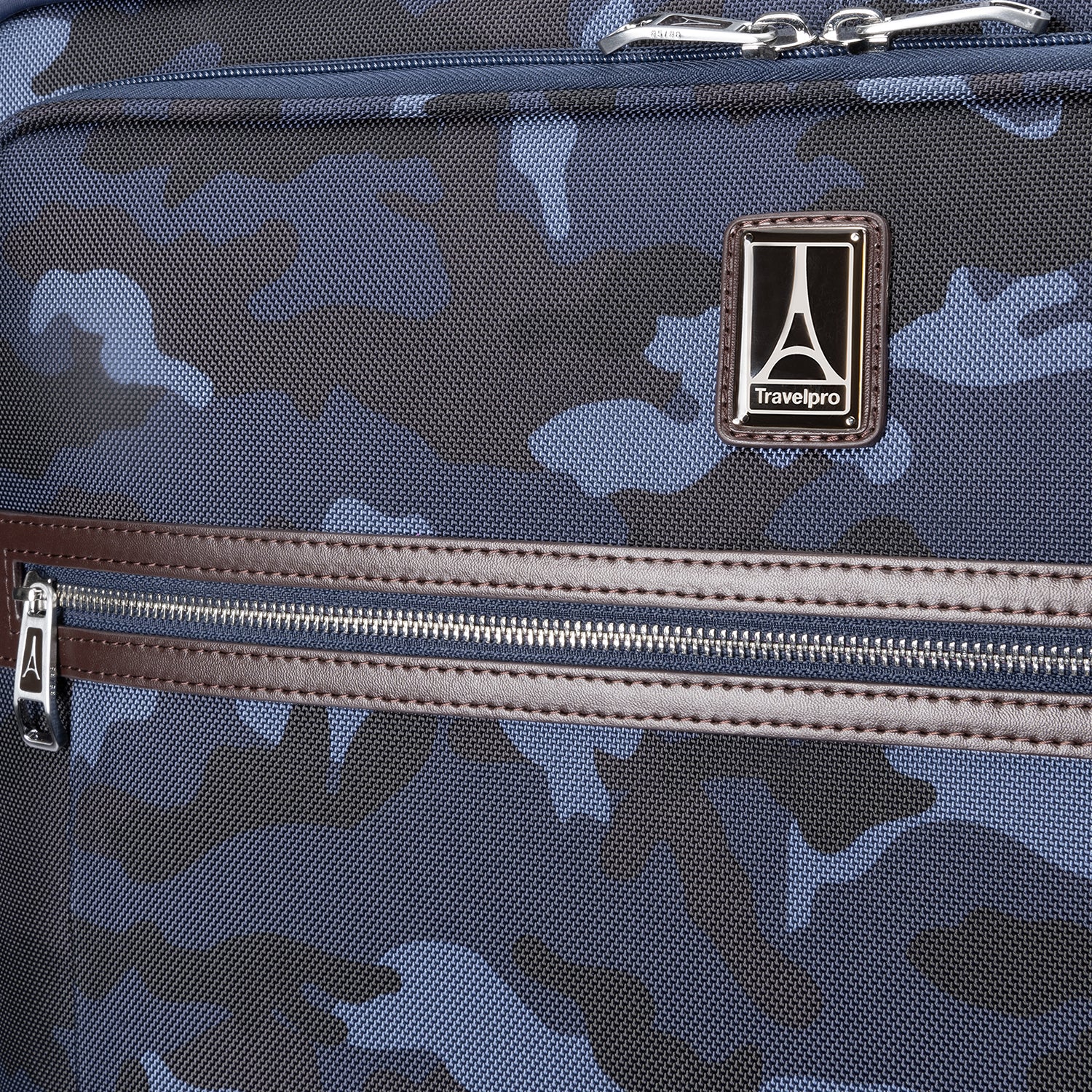 Close-up of the Platinum® Elite Large Check-In Spinner in Camouflage, showcasing the Travelpro logo and front zippered pocket with leather trim.