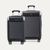 A set of two black hardside spinner suitcases, one carry-on size and one medium check-in size, with the travelpro logo on the top.
