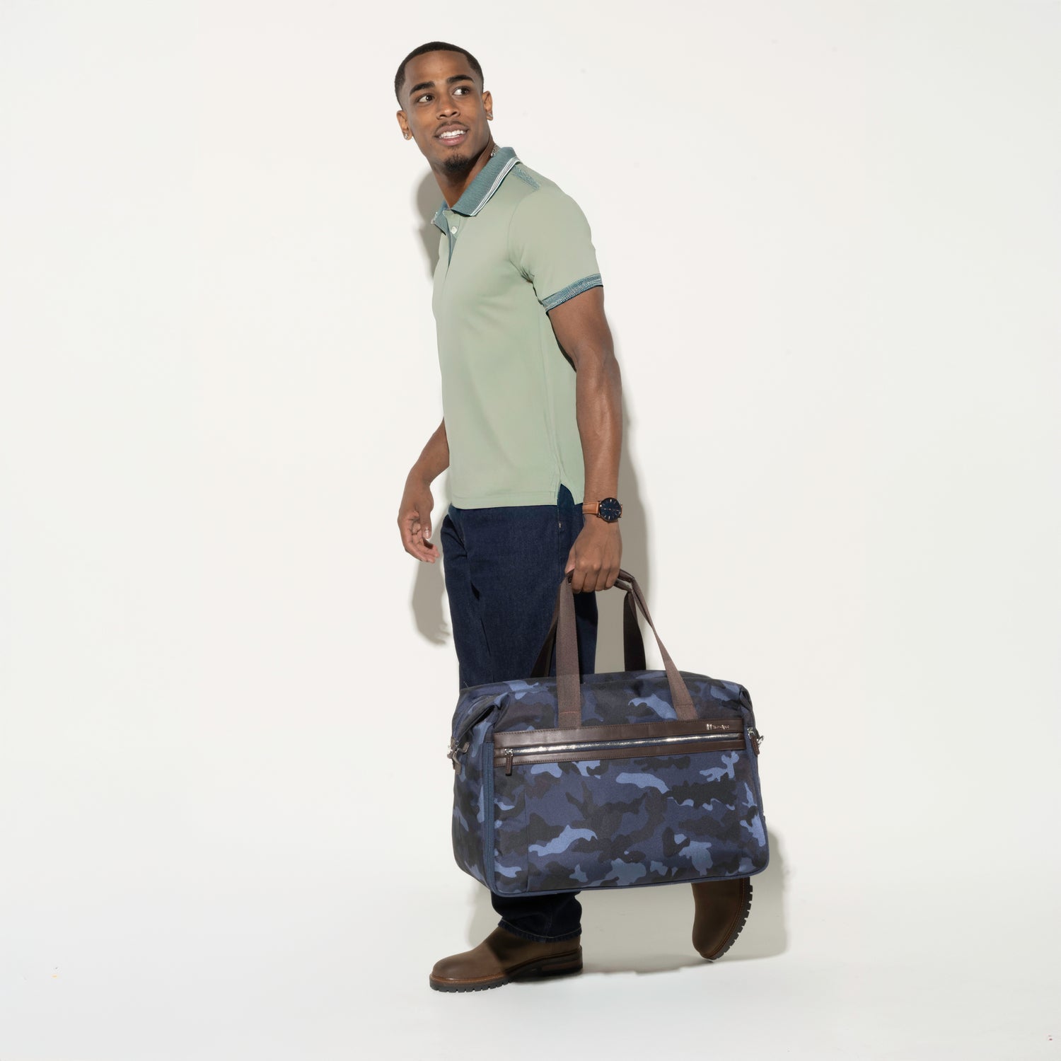 Man holding the Platinum® Elite Soft Duffel in Camouflage, showcasing its sleek design, convenient top carry handles