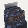 **Alt text:** Platinum® Elite Business Backpack in camouflage, shown with a laptop partially inserted into its padded top compartment.