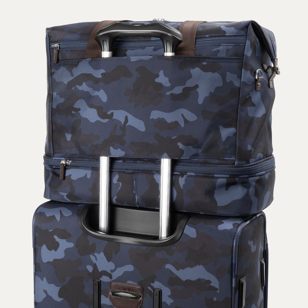 Rear view of Travelpro Platinum Elite Drop-Bottom Weekender in Navy Camouflage stacked on luggage handle using rear stacking strap.