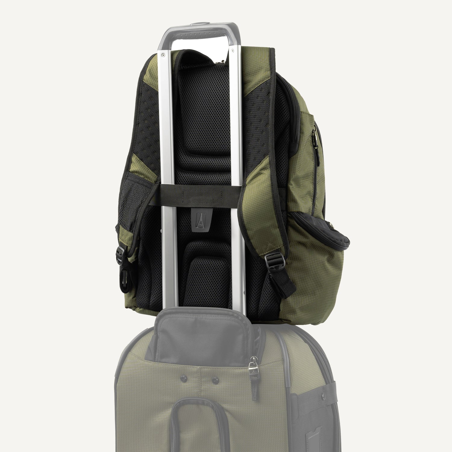 Green backpack stacked on top of a suitcase