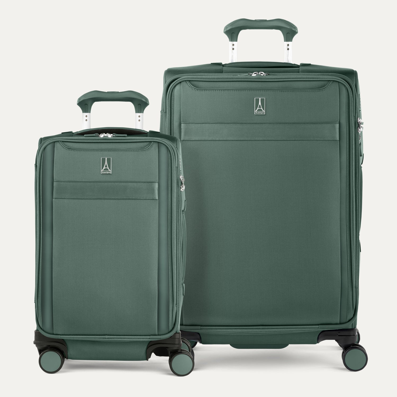Two green suitcases of different sizes on a light gray background