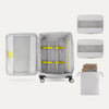 Open suitcase with packing accessories on a white background