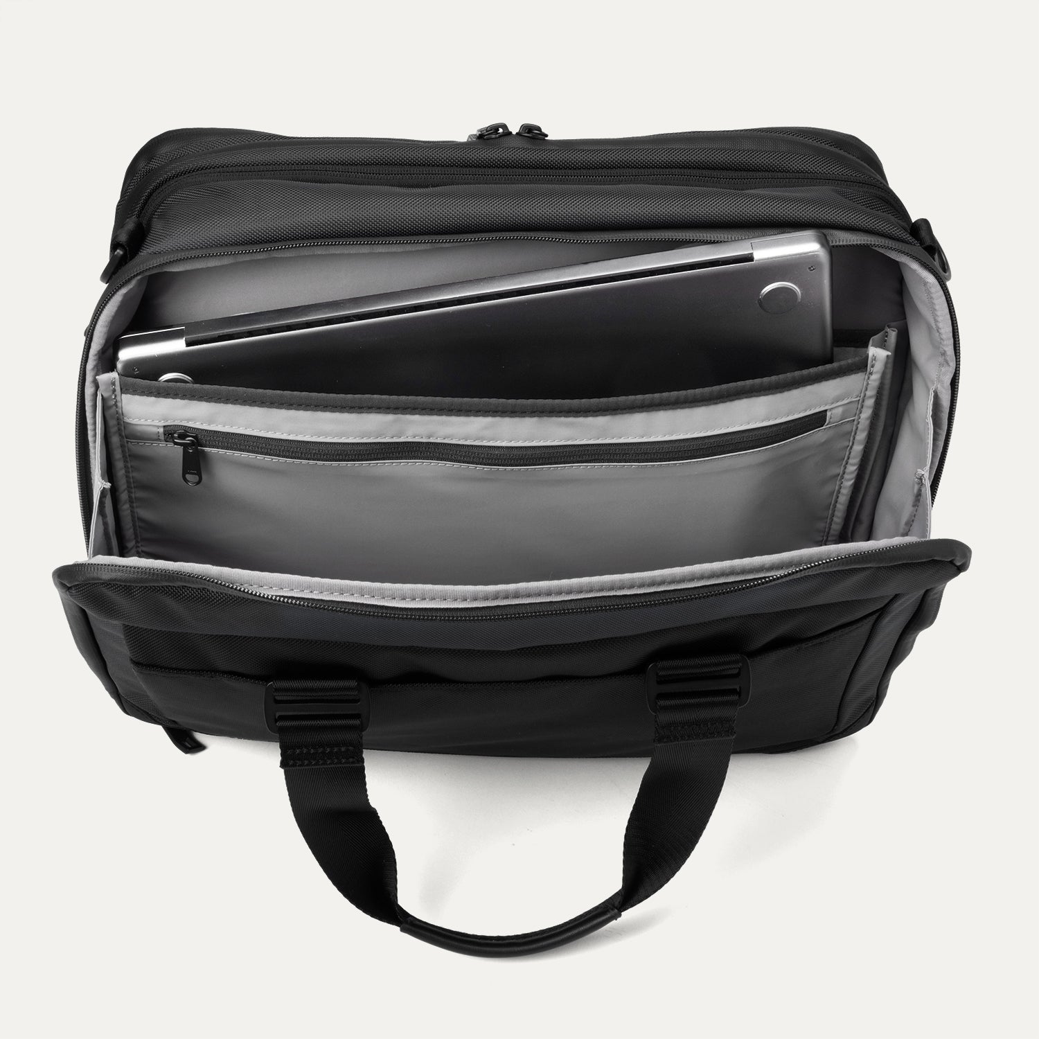 Top view of the rear compartment of the Travelpro® Altitude™ Full Expansion Brief in black, open to reveal a padded laptop sleeve, a zippered pocket, and multiple organizational slots for documents and accessories.