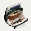 Green backpack with compartments containing electronic devices on a white background