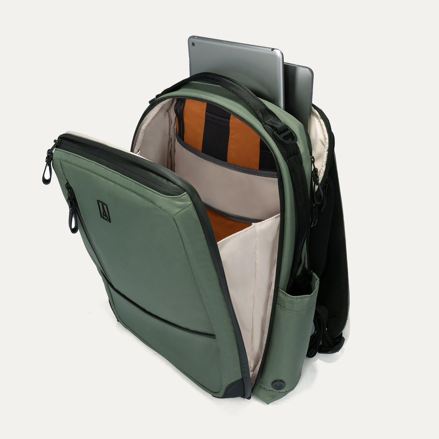 Green backpack with open compartment showing a laptop and orange interior.