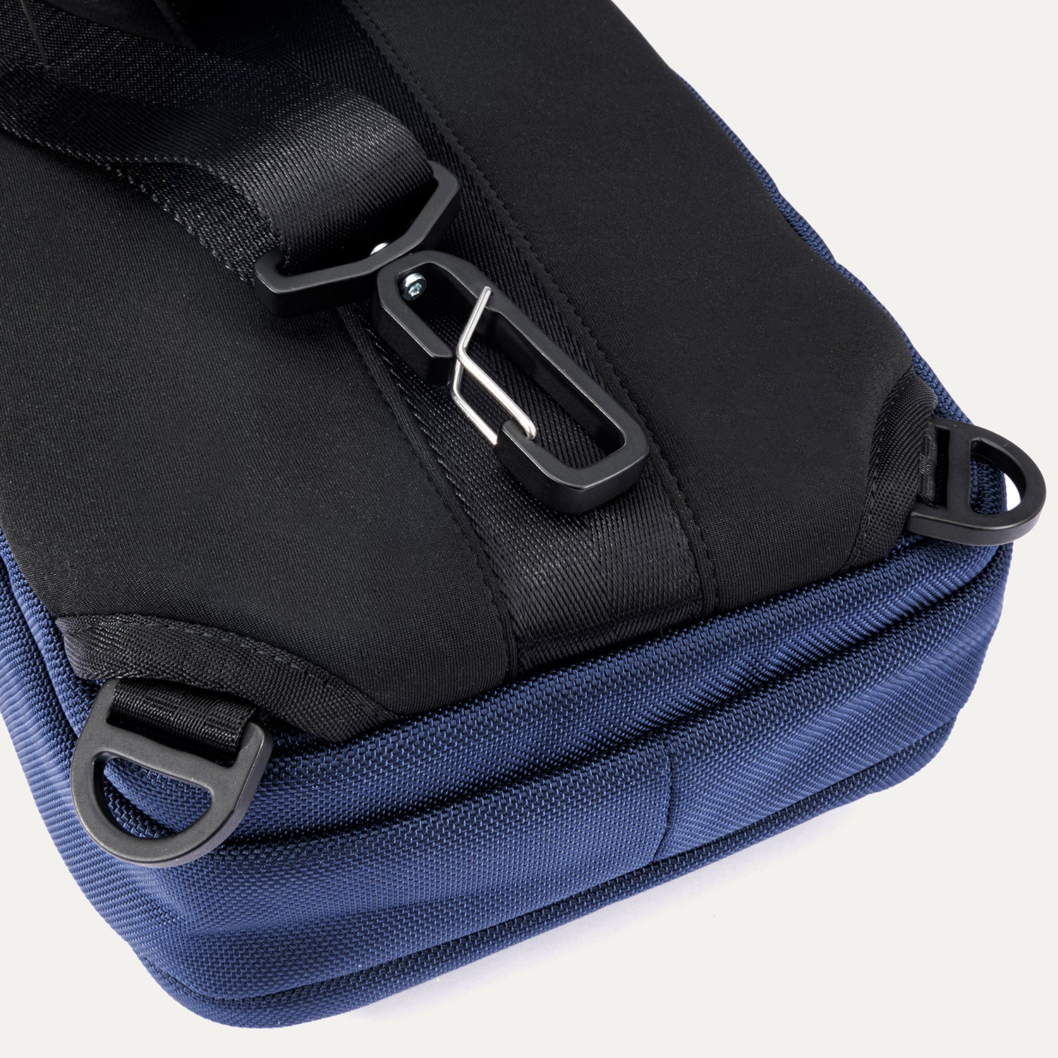 Close-up rear view of the Travelpro Altitude Crossbody 6L in Aviator Navy, showing D-rings and rear clip attachment detail.