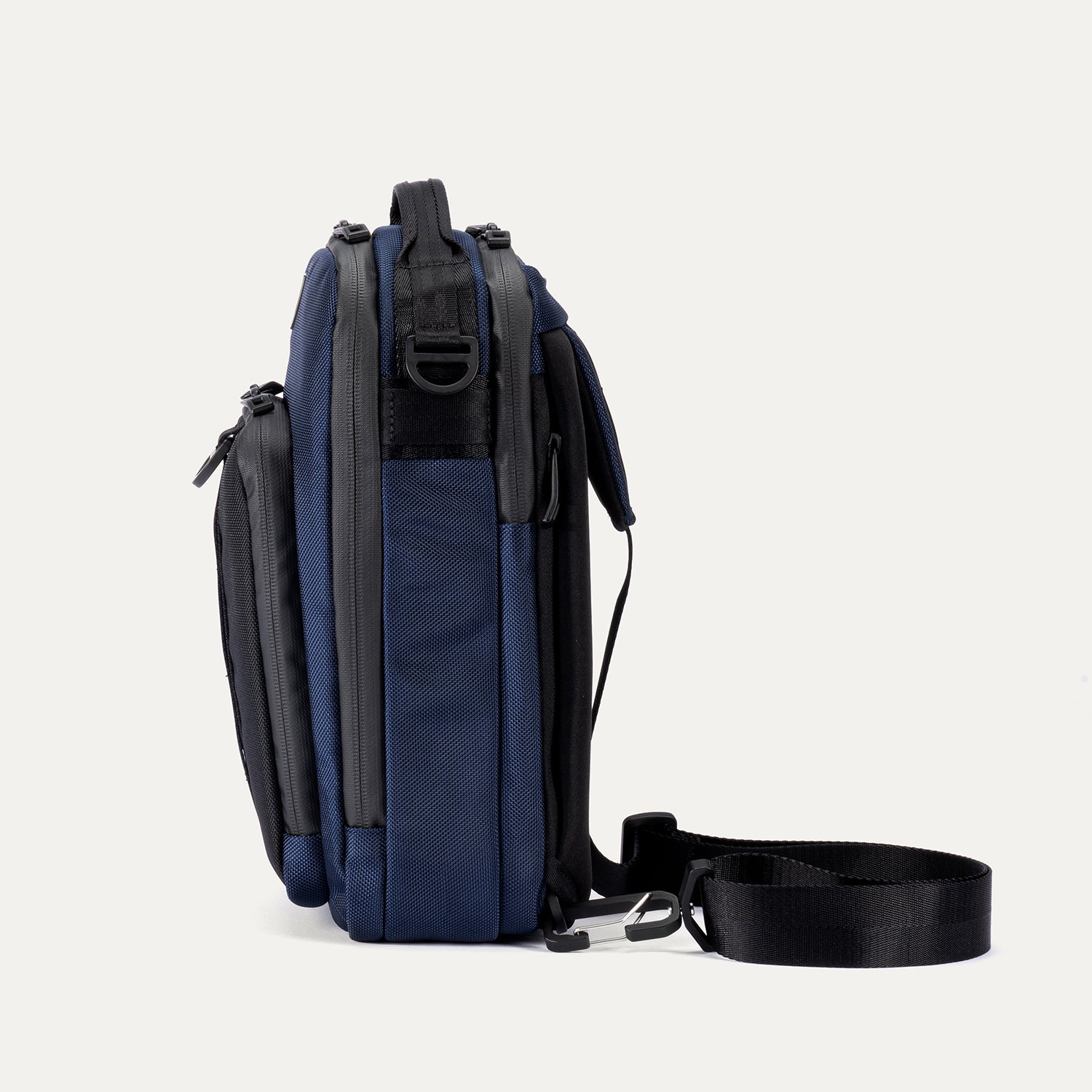 Side view of Travelpro Altitude Crossbody 6L in Aviator Navy, showing compression straps and clip attachment points.