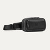 Travelpro Altitude Sling 2L in Jet Black, showing front zip pocket and adjustable strap with Travelpro tag.