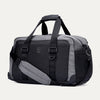 Angled front view of the Travelpro Altitude Day-to-Day Duffel in Falcon Grey, highlighting the zippered pocket and adjustable shoulder strap.