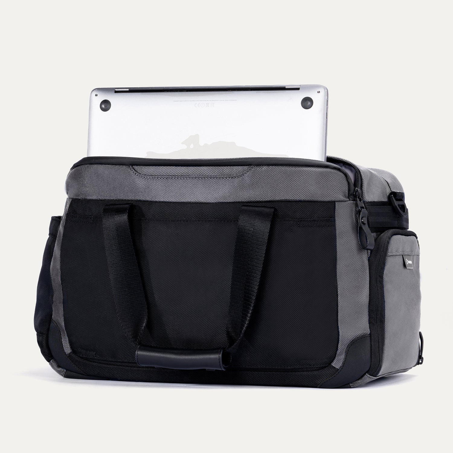 Rear view of the Travelpro Altitude Day-to-Day Duffel in Falcon Grey, showing laptop partially stowed in padded sleeve.