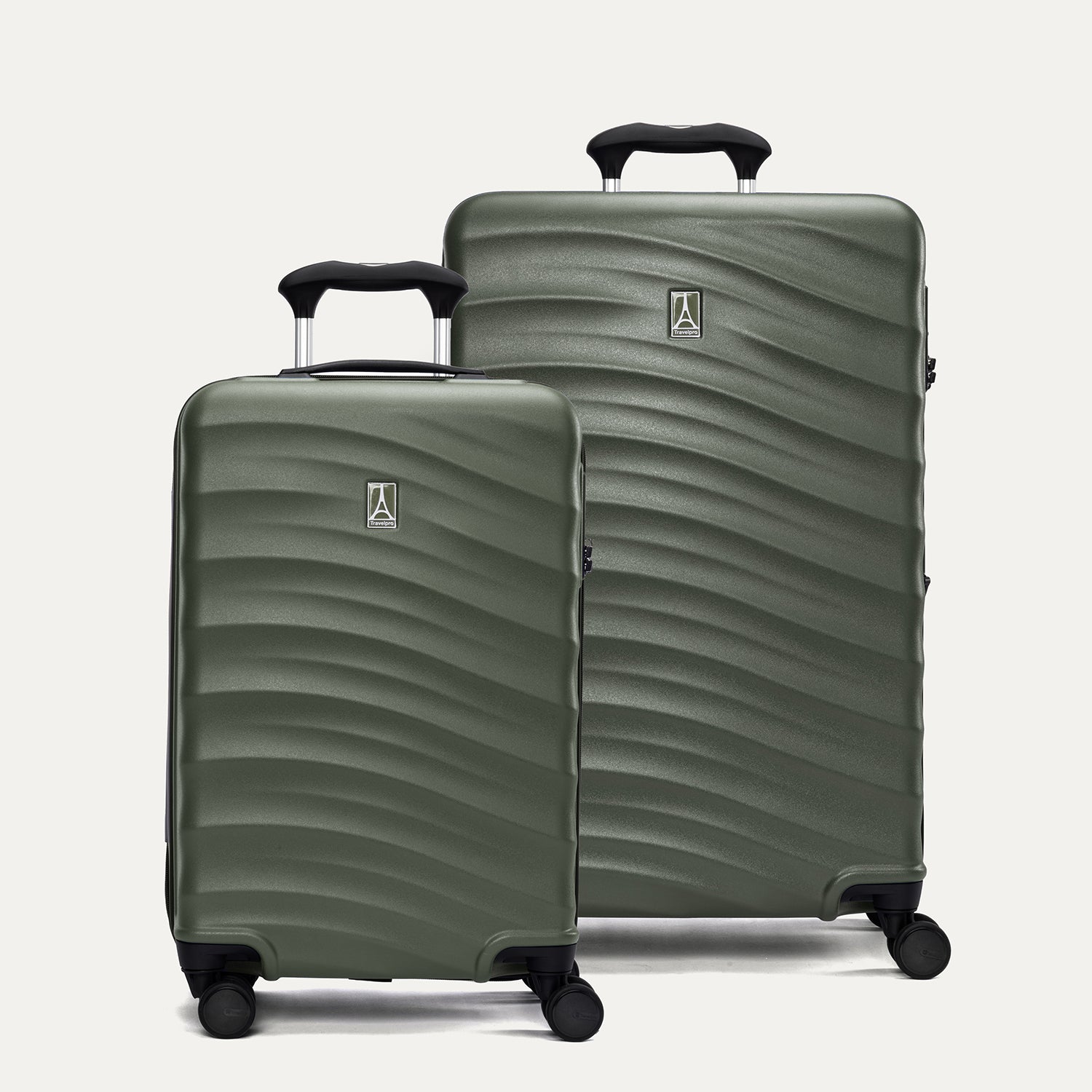 A set of two green hardside spinner suitcases, one carry-on size and one medium check-in size, with a textured surface, black handles, and wheels.