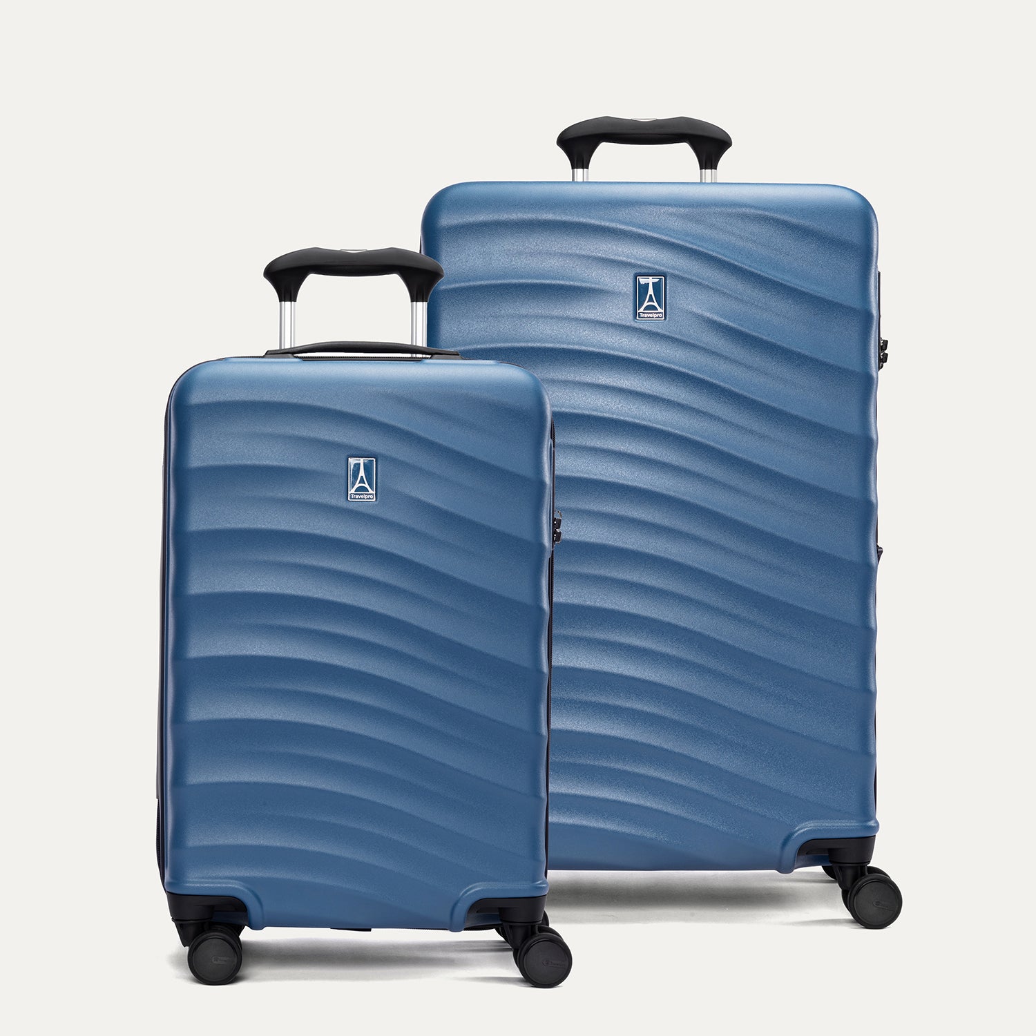 A set of two blue hardside spinner suitcases, one carry-on size and one medium check-in size, with a pattern on the shell on a white background