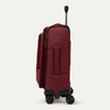 Side view of red suitcase with handle and wheels on a white a background