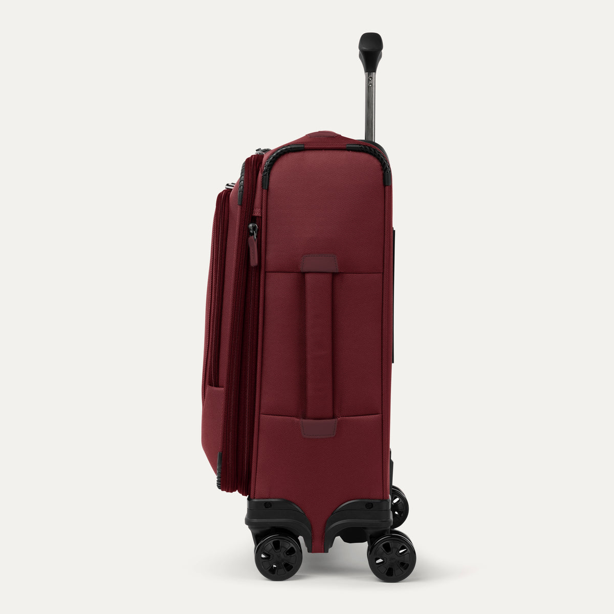 Side view of expanded red suitcase with black wheels and handle on a white background