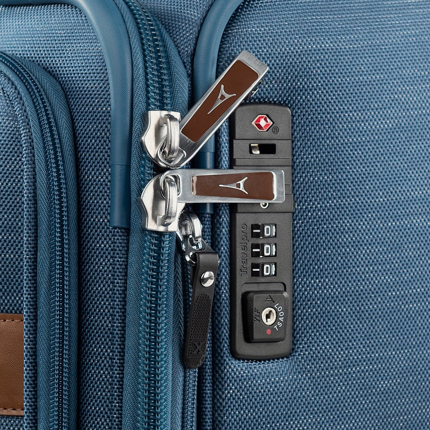 Close-up of suitcase locks and zipper pulls on a blue suitcase.