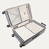 Open suitcase with closed compartments and black wheels on a white background