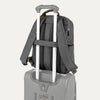 Vintage Gray backpack with a rear strap over suitcase handle on a white background