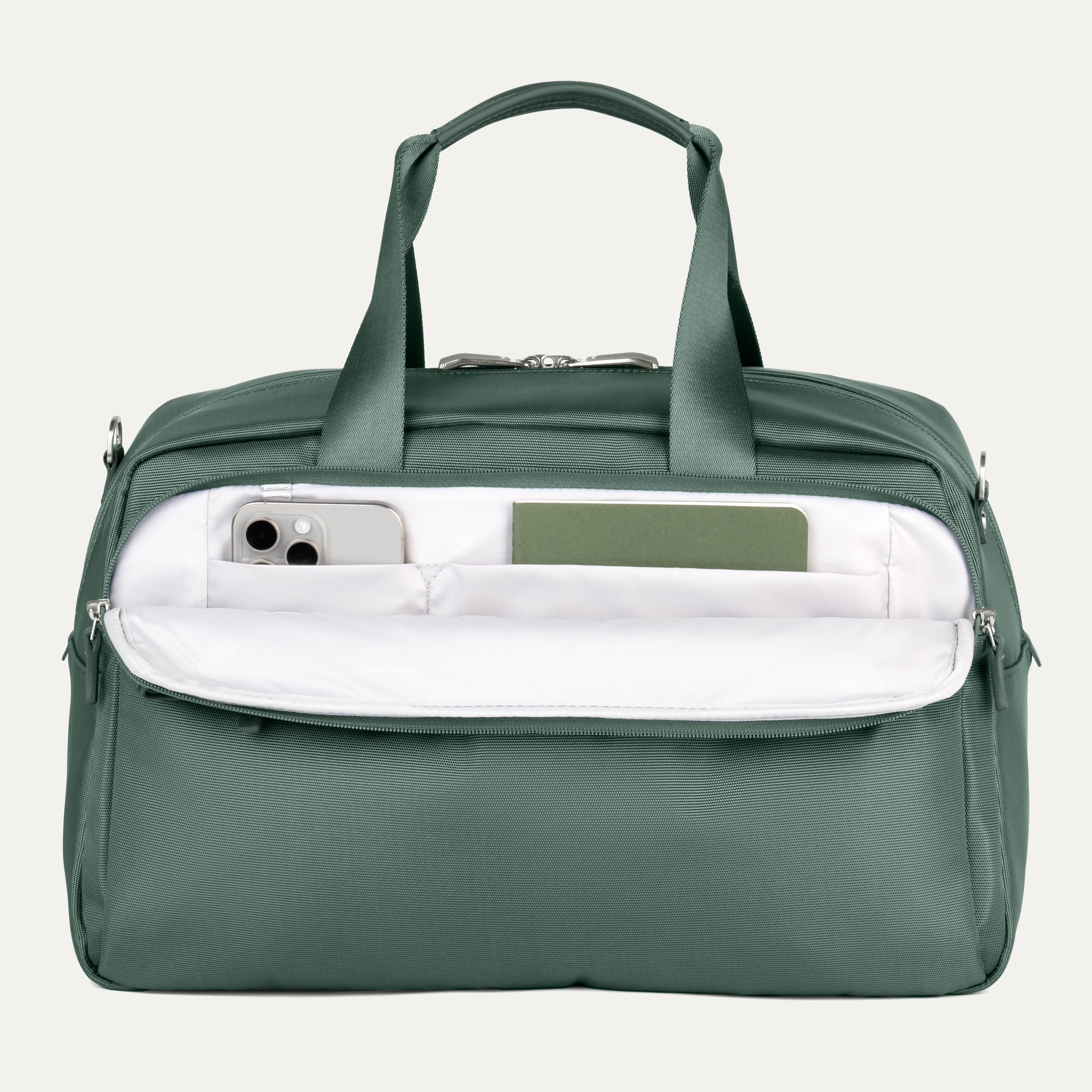 Green travel bag with a white interior pocket showcasing phone and notebook on a light gray background