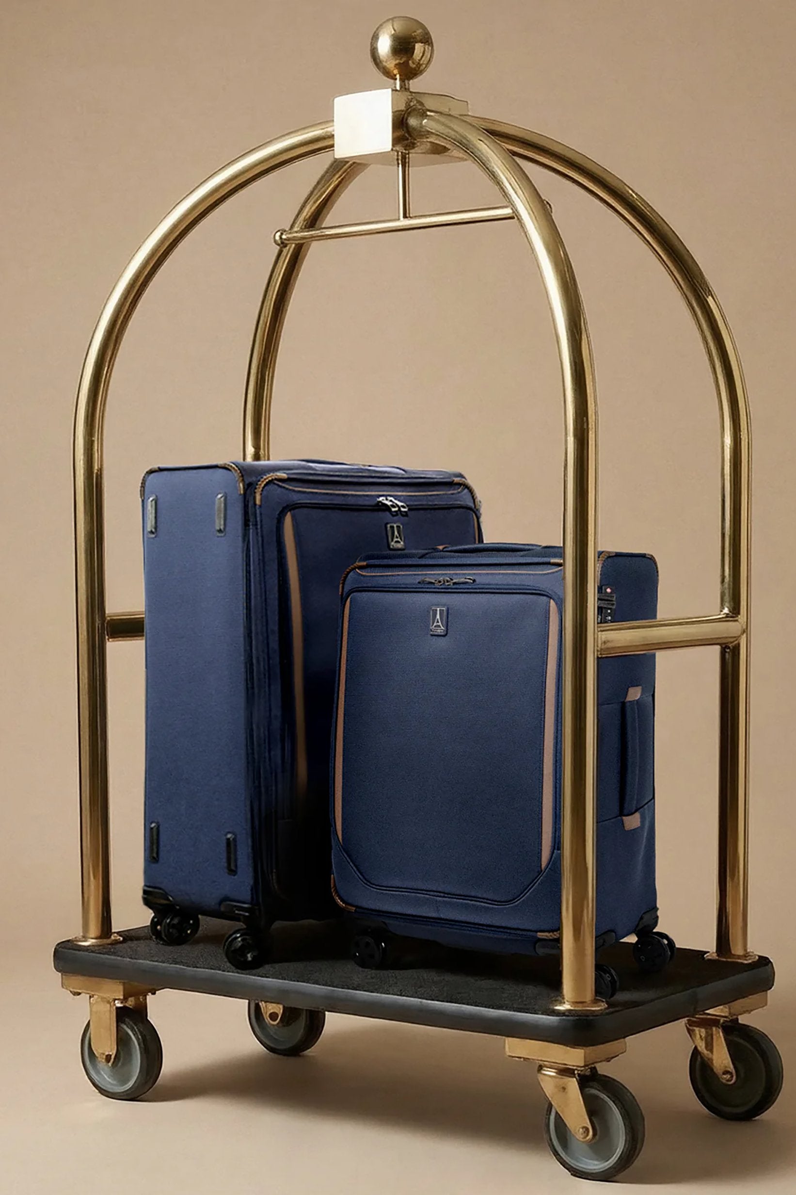 Gold luggage cart with blue suitcases on a beige background
