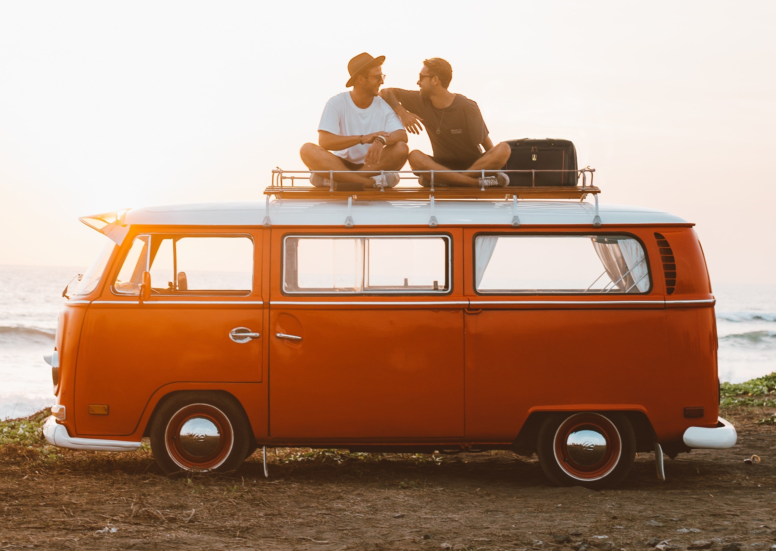 2 men sitting on top of a van