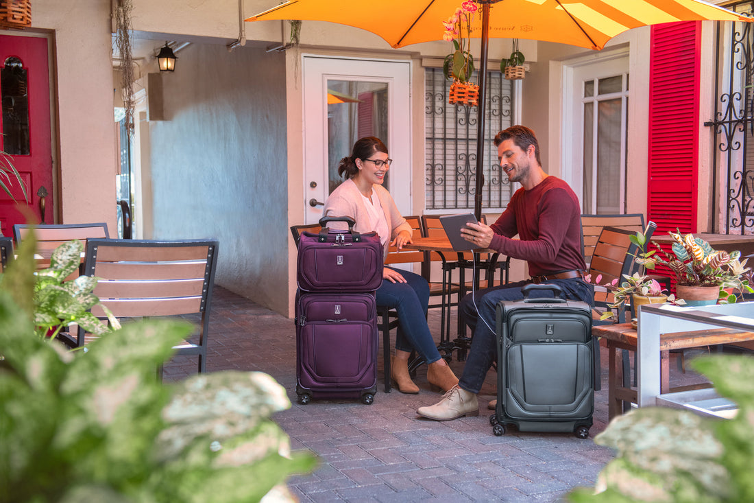 Man and woman with Travelpro spinner suitcase and carry on luggage set