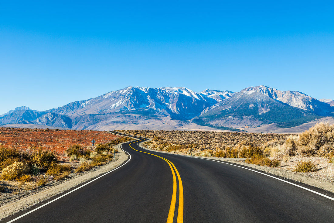open highway surrounded by mountains 