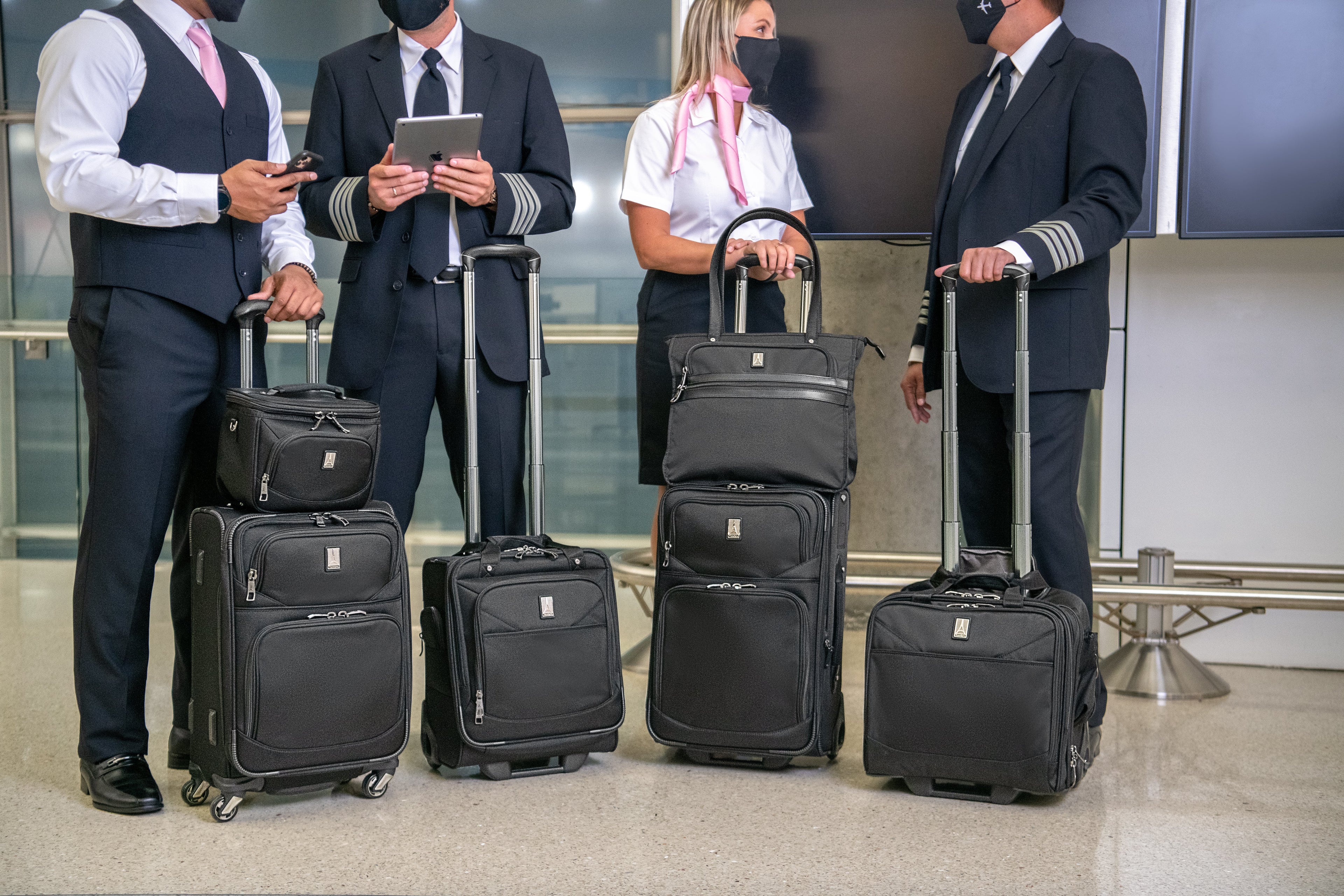 Flight crew professionals standing next to each other with luggage