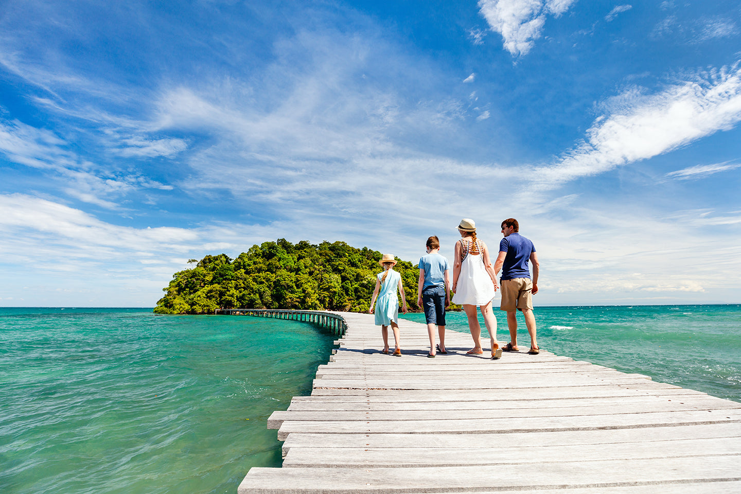 Family walking on boardwalk over the ocean