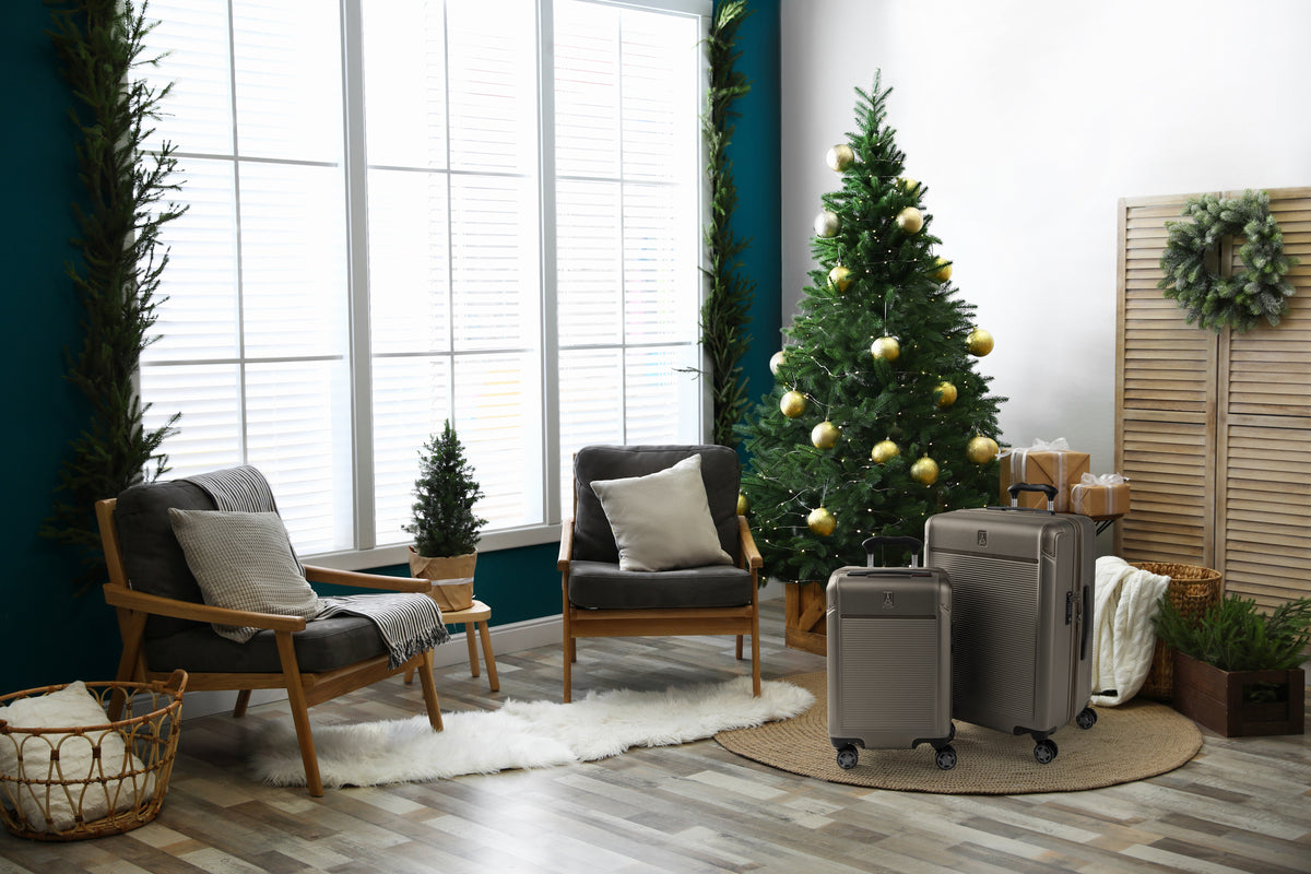 Platinum Elite carry on and check in metallic sand hardside luggage in the living room next to a christmas tree